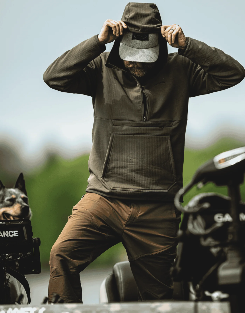 Angler in boat wearing Simms Strata 330 Half-Zip Midlayer Hoody