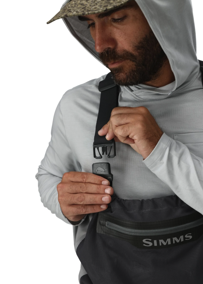 Man clipping strap of Simms Flyweight Packable Waders