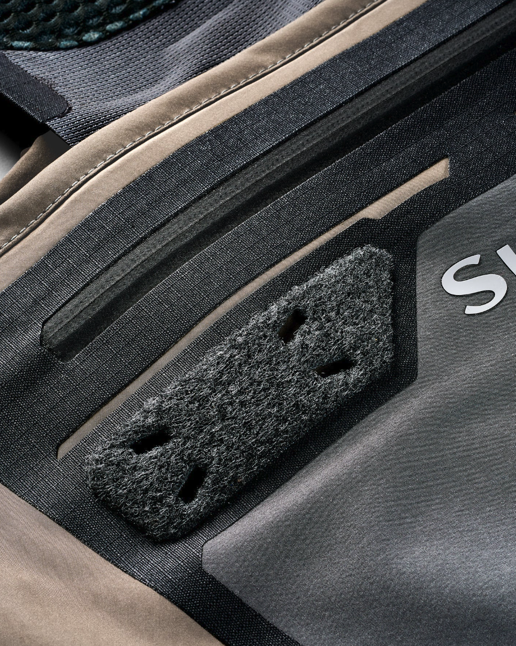 Close-up of Simms G3 Pro Guide fishing waders showing chest pocket zipper and fly fishing accessory docking patch