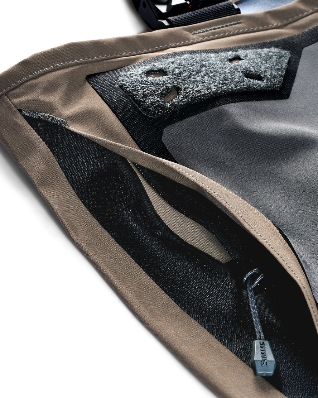 Close-up of Simms G3Z Pro Guide fly fishing waders showing side-entry handwarmer pocket and accessory patch