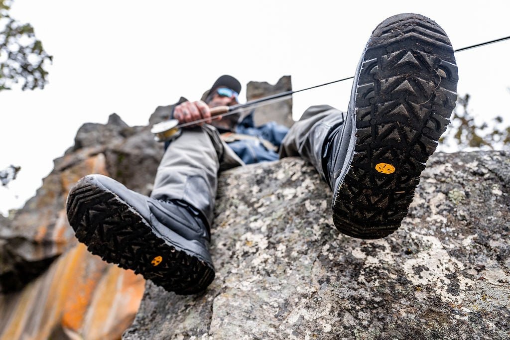 Angler climbing rock ledge wearing Skwala RS wading boots with Vibram IDROGRIP traction soles