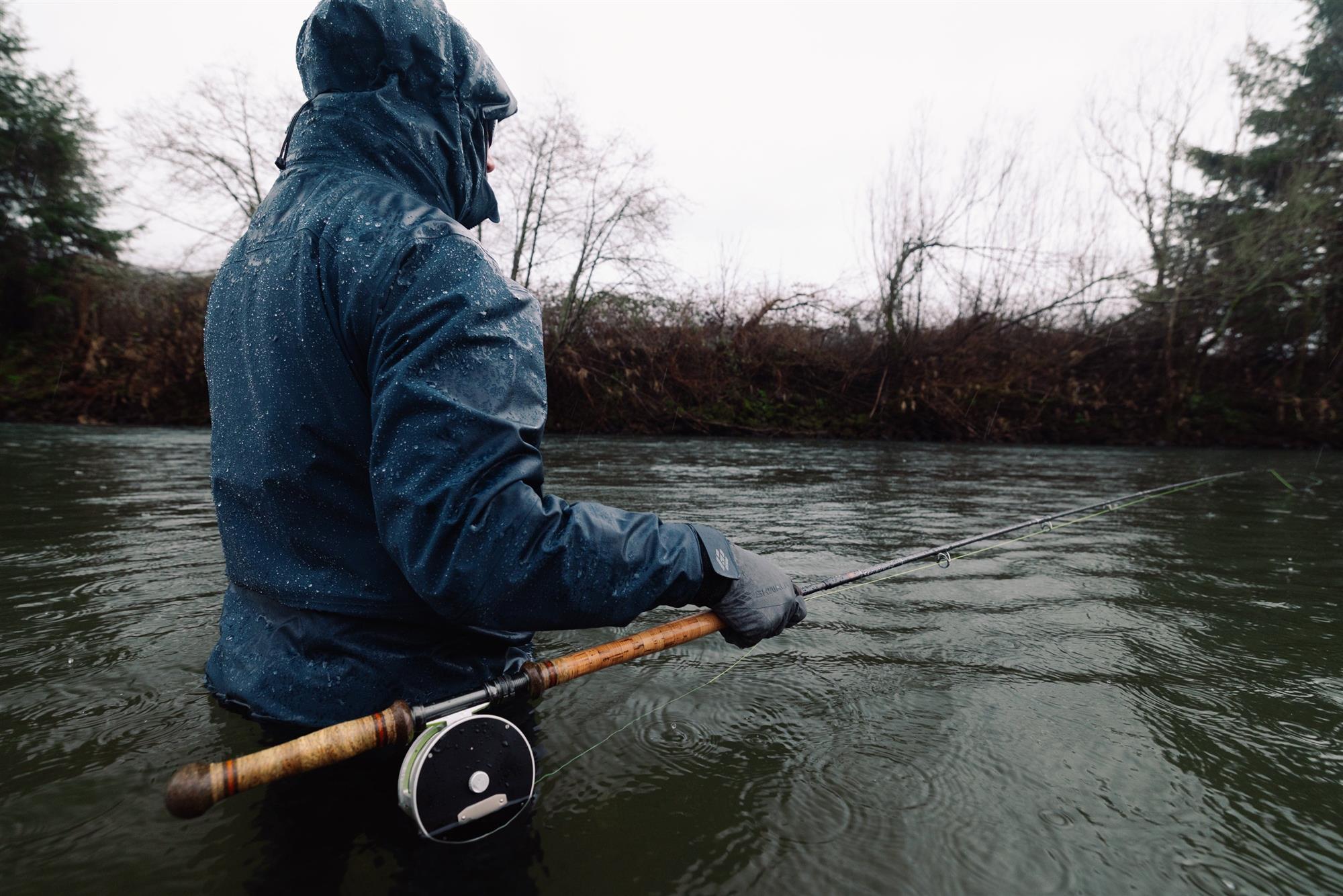 Angler fly fishing in rain wearing Skwala RS Waterproof Gloves cold weather waterproof fly fishing gloves