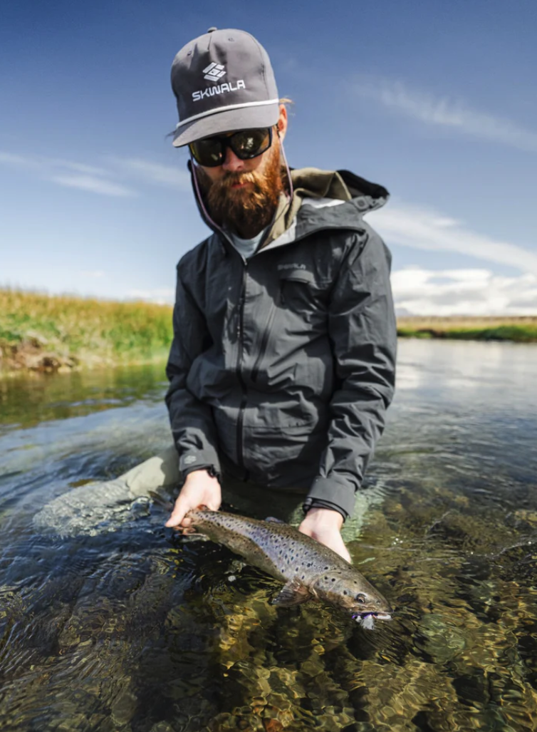Angler wearing Skwala Icon Rope Hat releasing fish