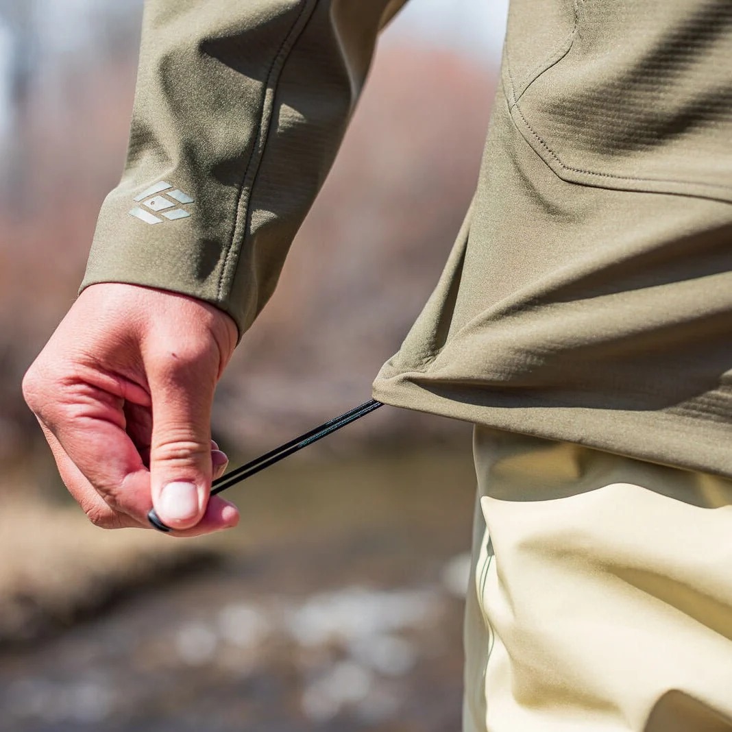 - DWR fishing softshell jacket hem adjustment detail for wind protection and active outdoor use