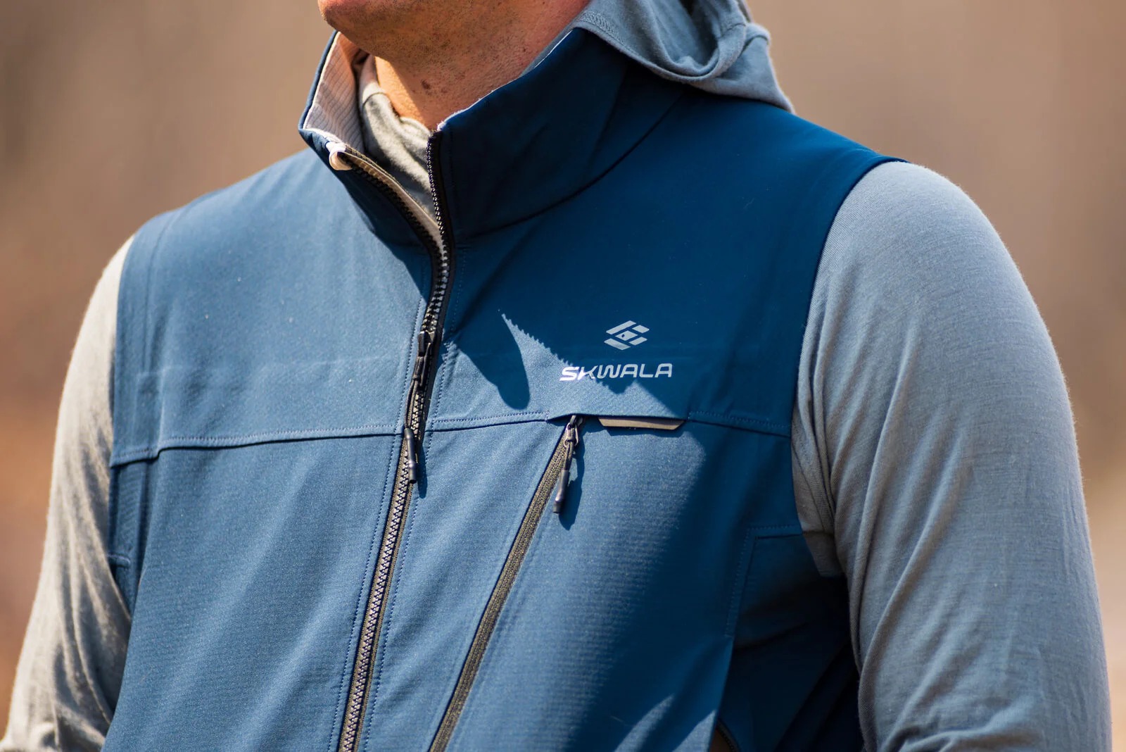 Men's windproof fly fishing vest layered over hoodie for cold mornings and outdoor adventures