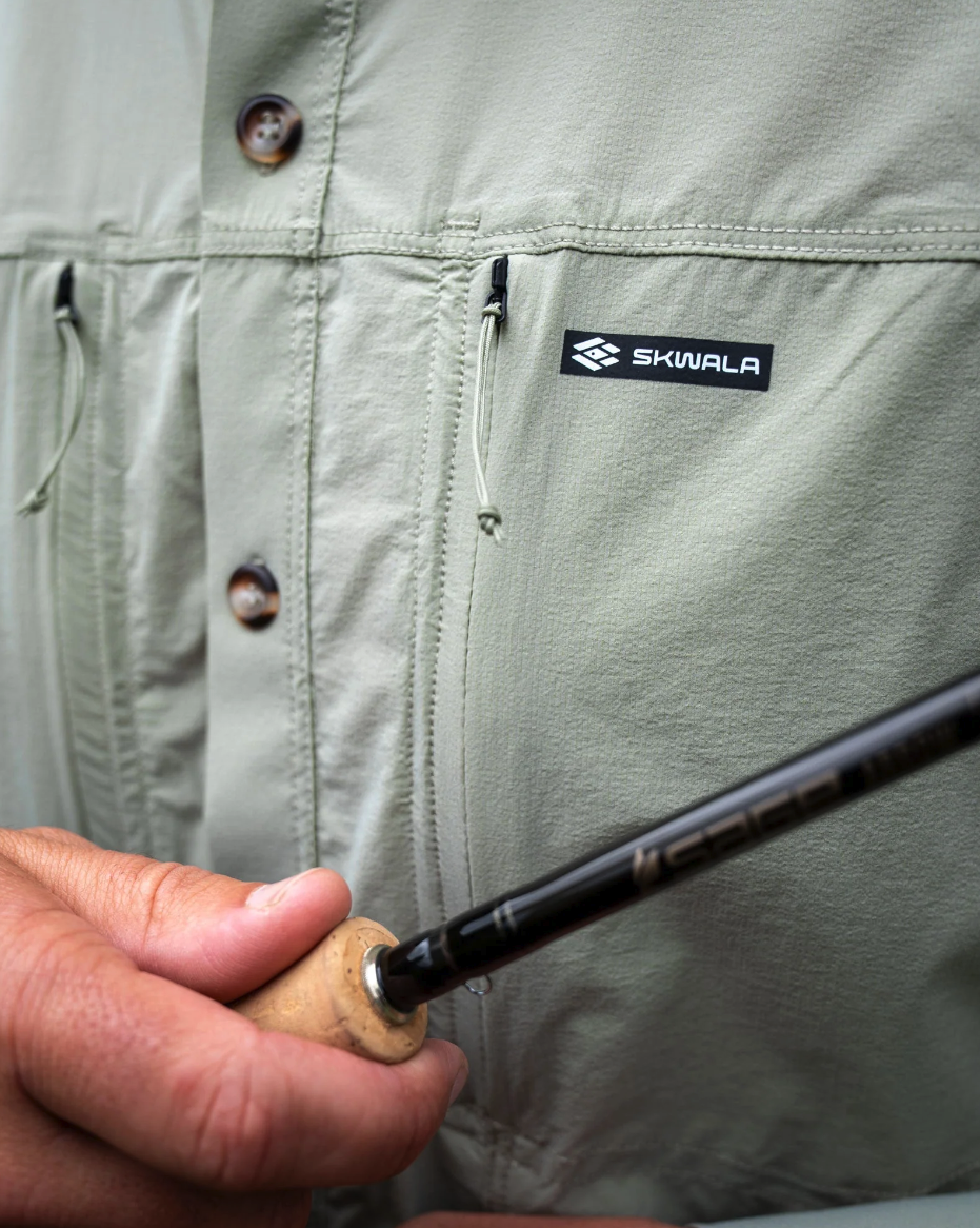 Angler holding fly rod near chest pocket of Skwala Sol Breeze Shirt
