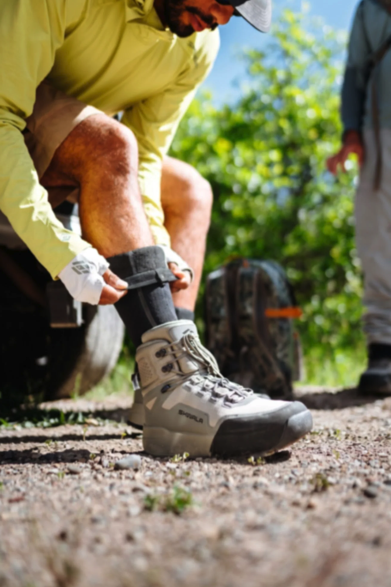 Angler folding down Skwala Backeddy Wet Wading Sock on boots