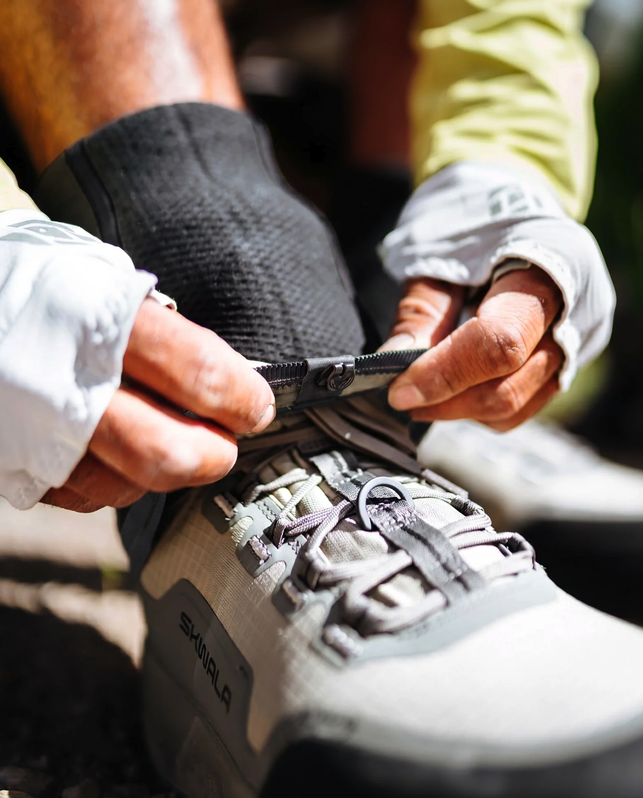 Angler putting Skwala Backeddy Wet Wading Sock over boots