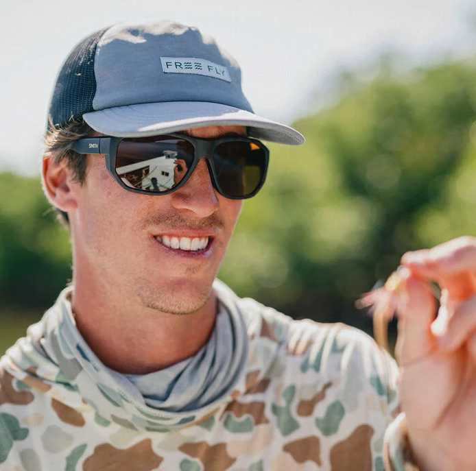 Angler looking at fly through Smith Outrigger Polarized Sunglasses
