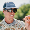 Angler looking at fly through Smith Outrigger Polarized Sunglasses