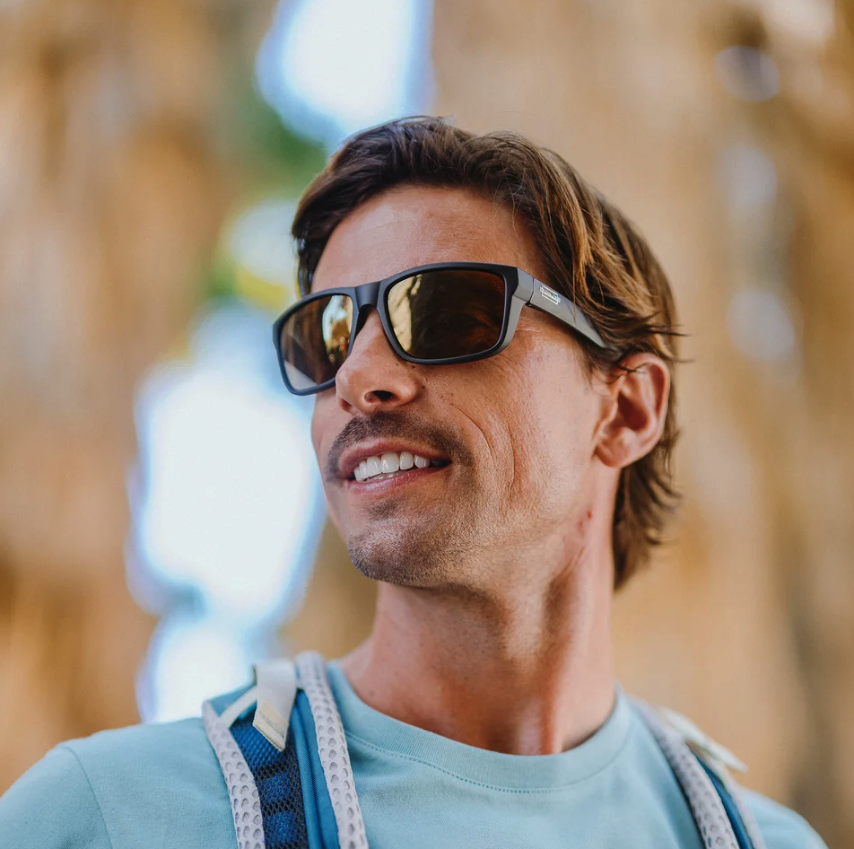 Angled view of man looking to side wearing Suncloud Mayor Polarized Sunglasses Matte Black Sienna Mirror