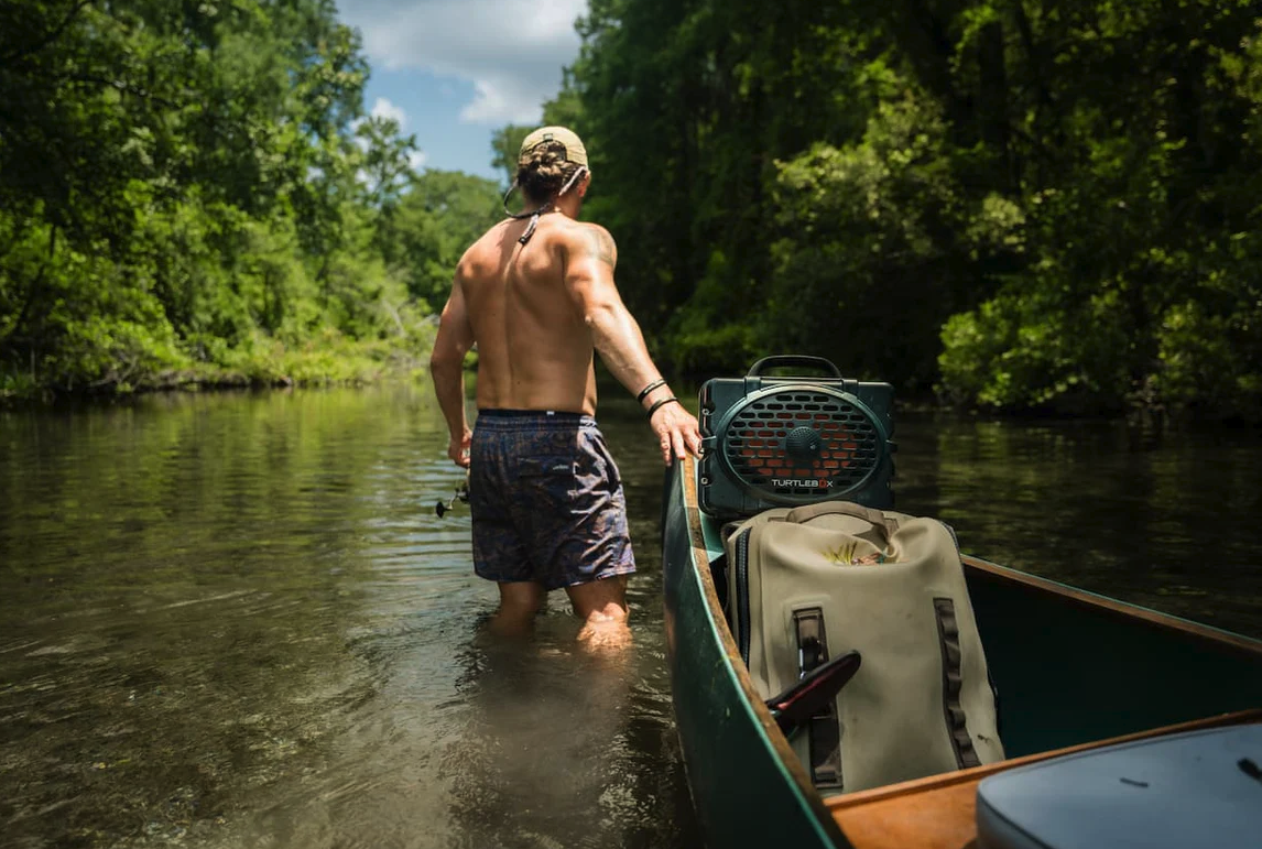 Turtlebox Original Speaker in canoe being pulled up river