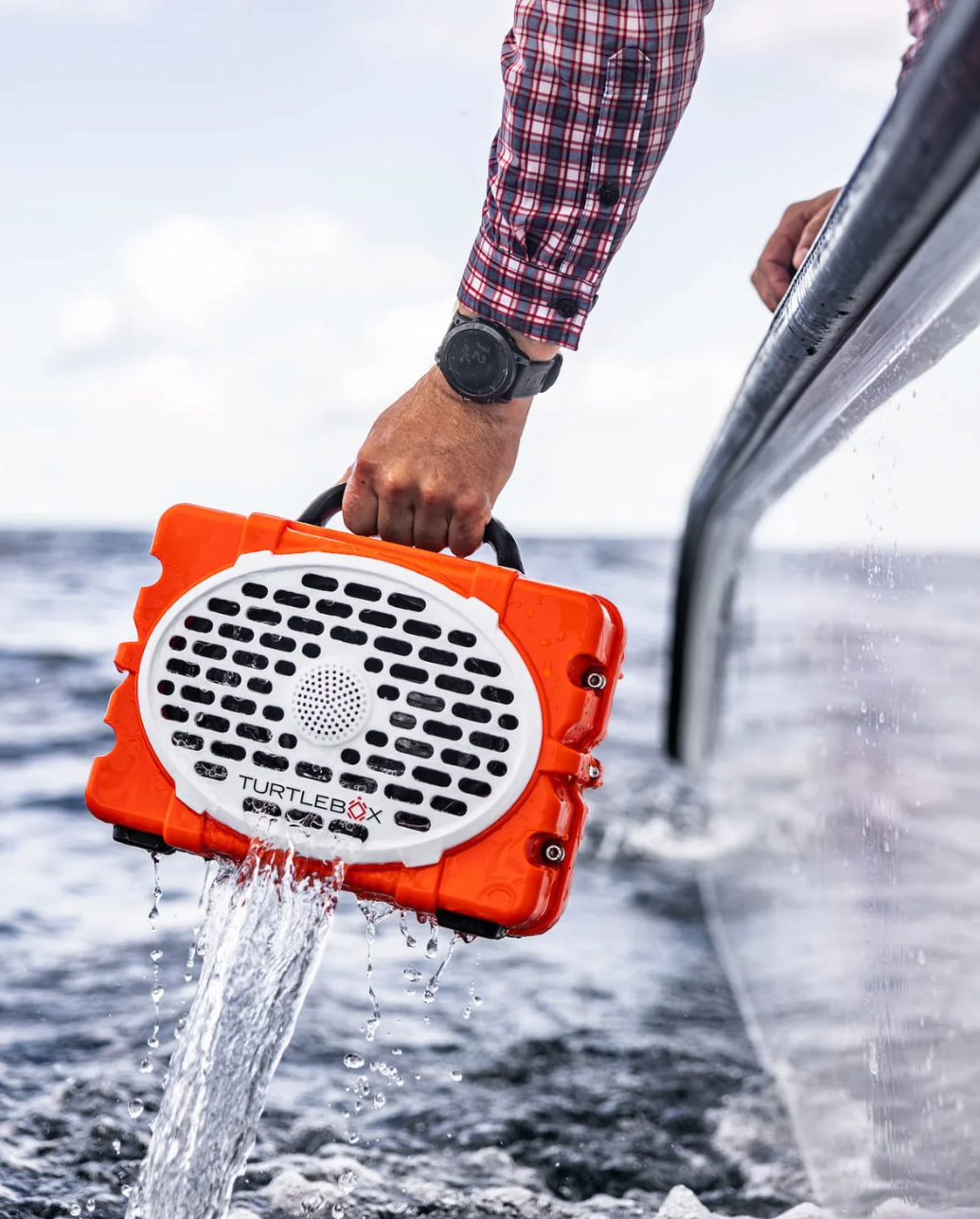 Turtlebox Original Speaker being pulled out of water into boat.