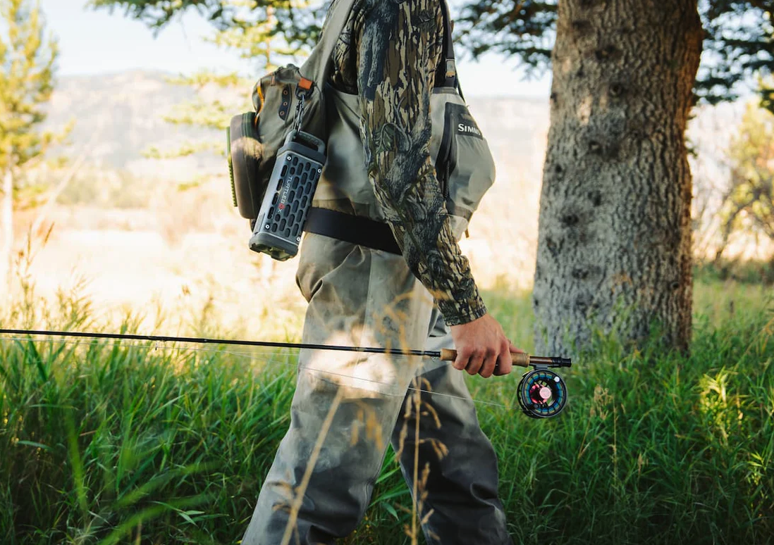 Fly angler walking with Turtlebox Ranger Speaker on pack.