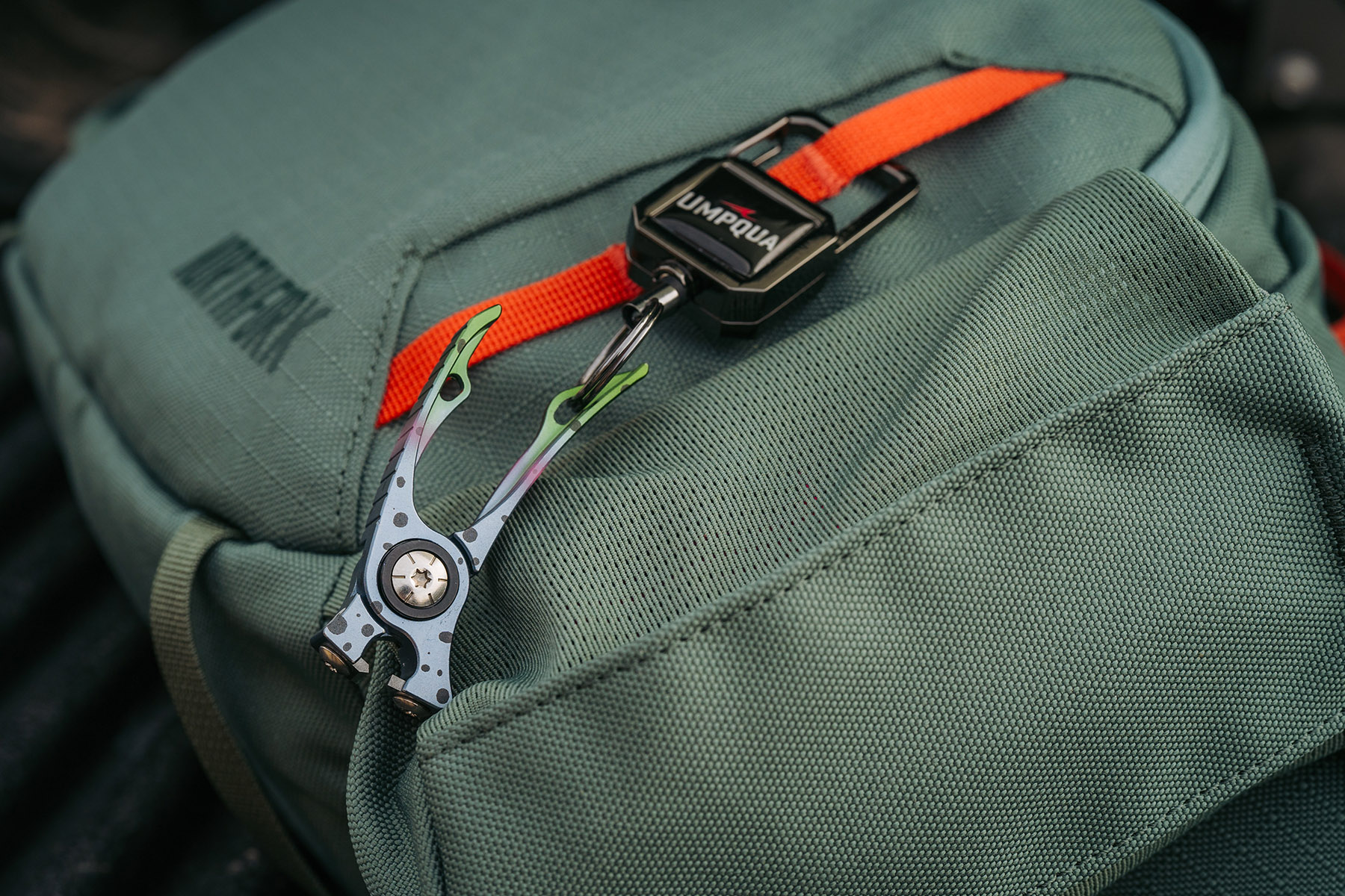 Umpqua RiverRun nippers rainbow trout pattern trimming tippet while tying fly detailed fly fishing tool close-up