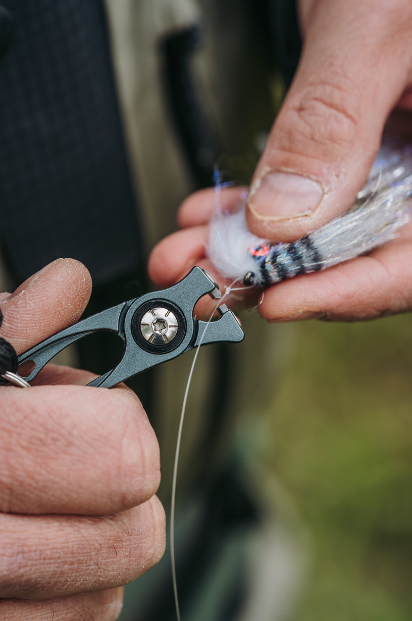 Angler cutting leader with Umpqua's RiverRun Nippers