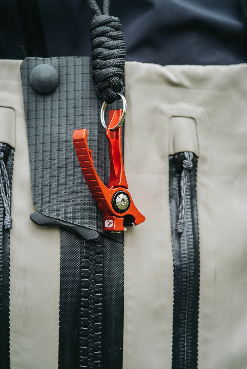 Pair of Orange Umpqua RiverRun Nippers and black lanyard hanging in front of waders