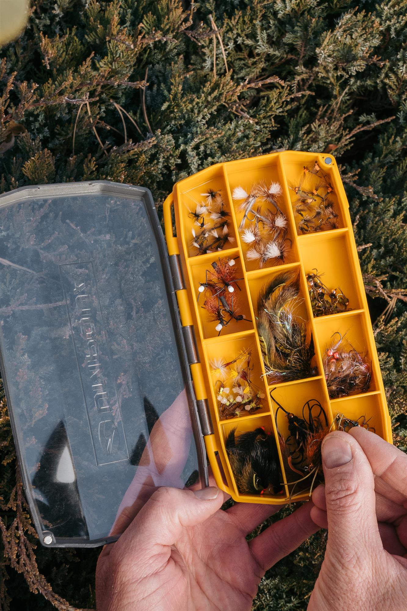 Umpqua UPG Compartment large fly box with flies, being held by an angler