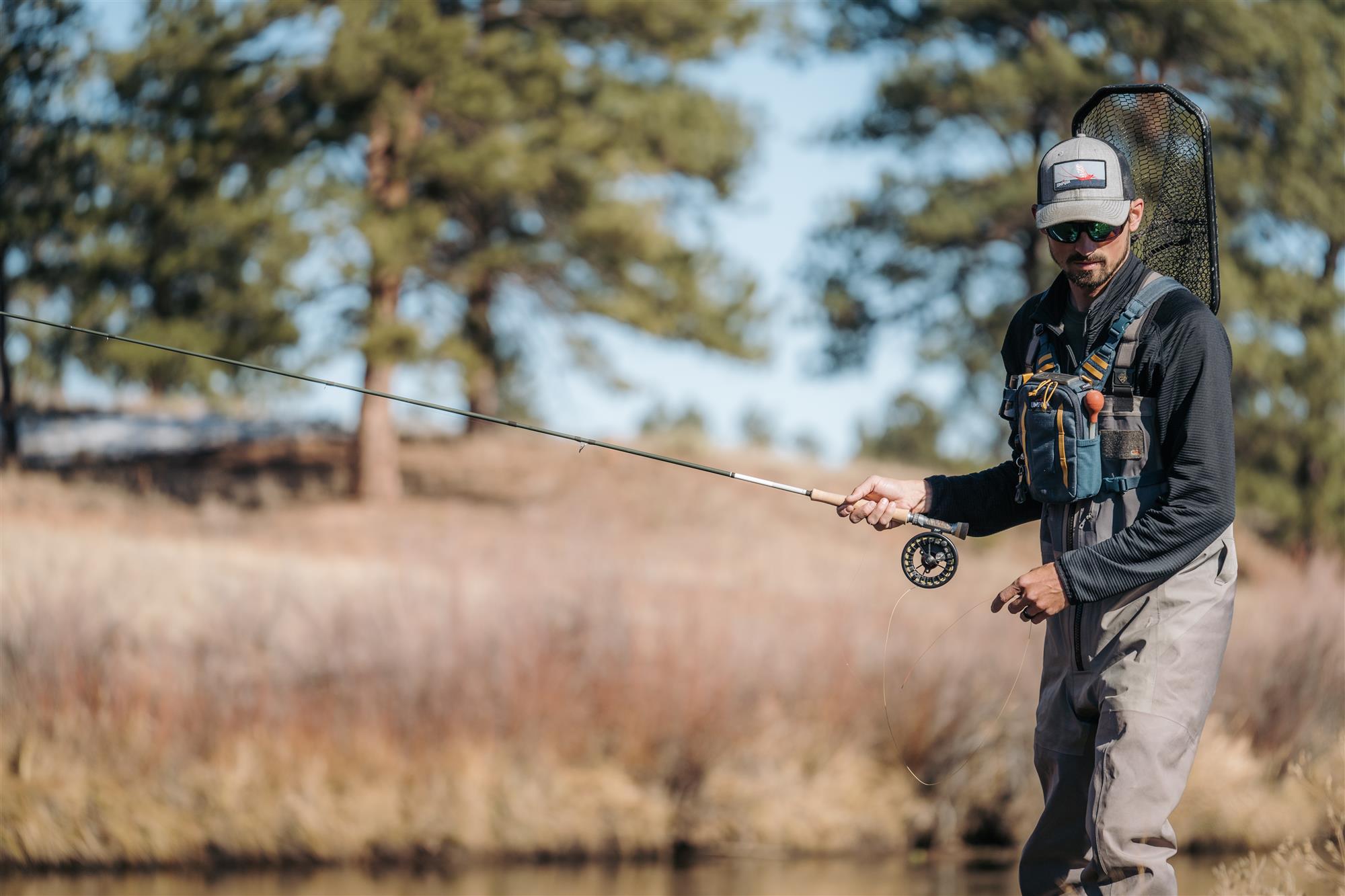 Angler fishing on a river while wearing the Umpqua North Fork Small Chest Pack