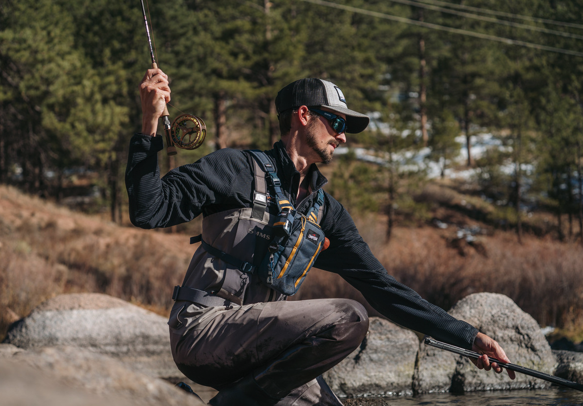 Angler landing fish wearing Umpqua NorthFork Small Chest