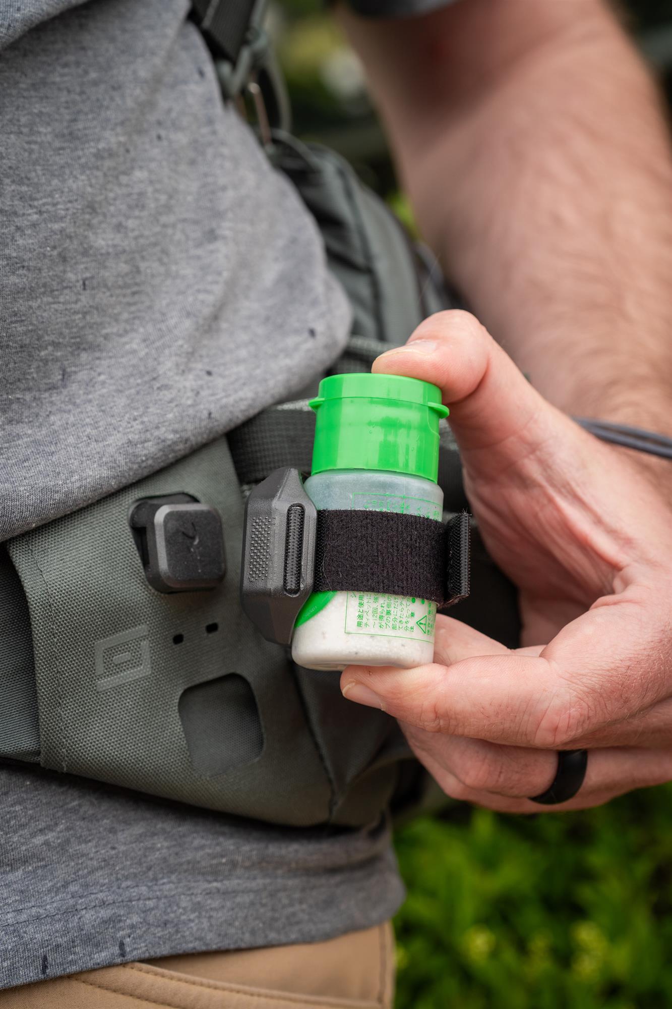 Fly fisherman using Umpqua DryDock floatant holder on waist pack magnetic fly fishing setup