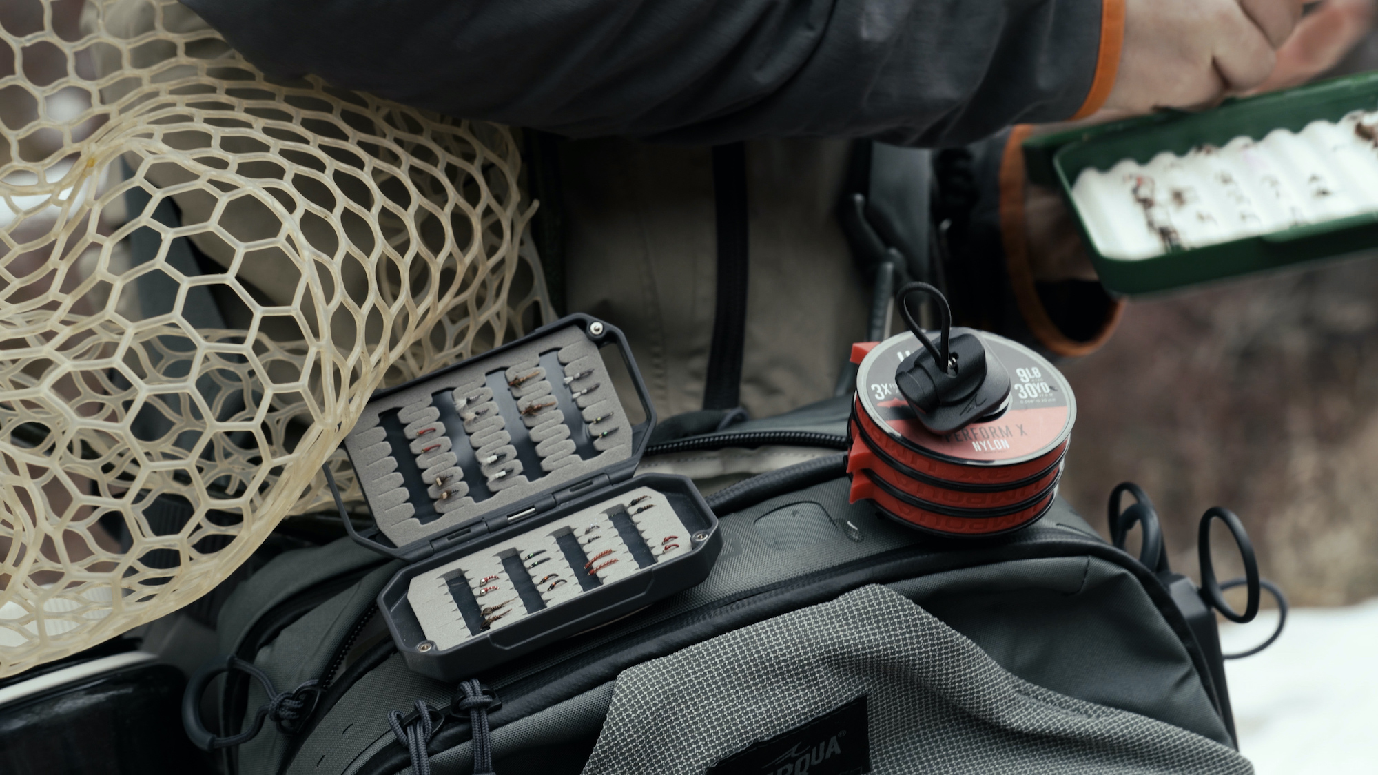 Umpqua HatchVault mounted on fishing pack strap with flies attached for on-water access