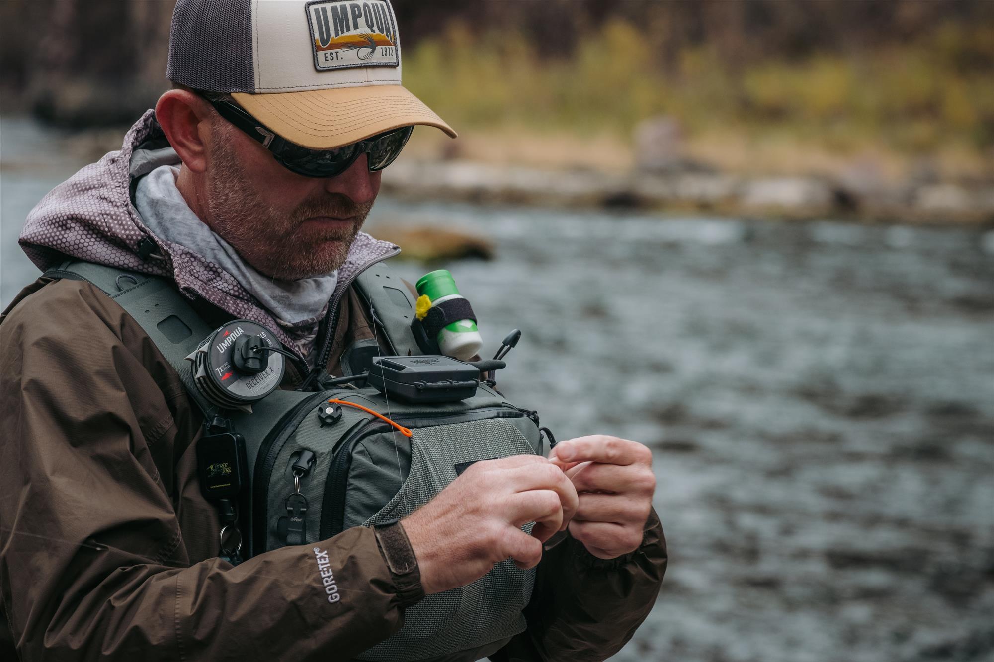 Fly fisherman using Umpqua LINK Tippet Tower on chest pack for fast rigging on river