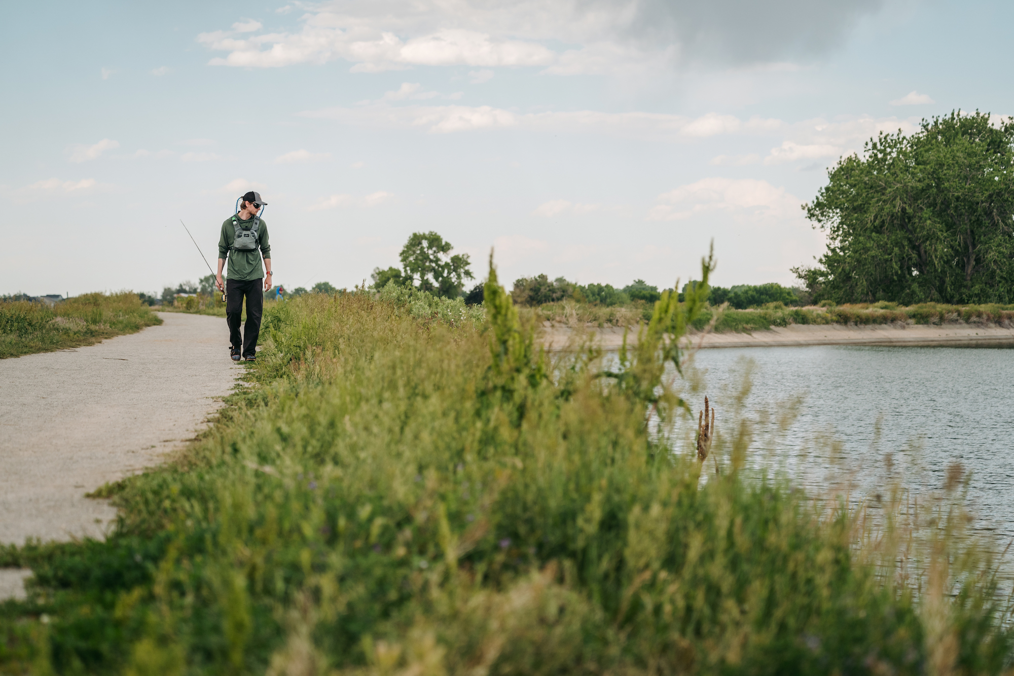 Angler walking trail wearing Umpqua ThunderCreek chest pack lightweight fishing gear setup