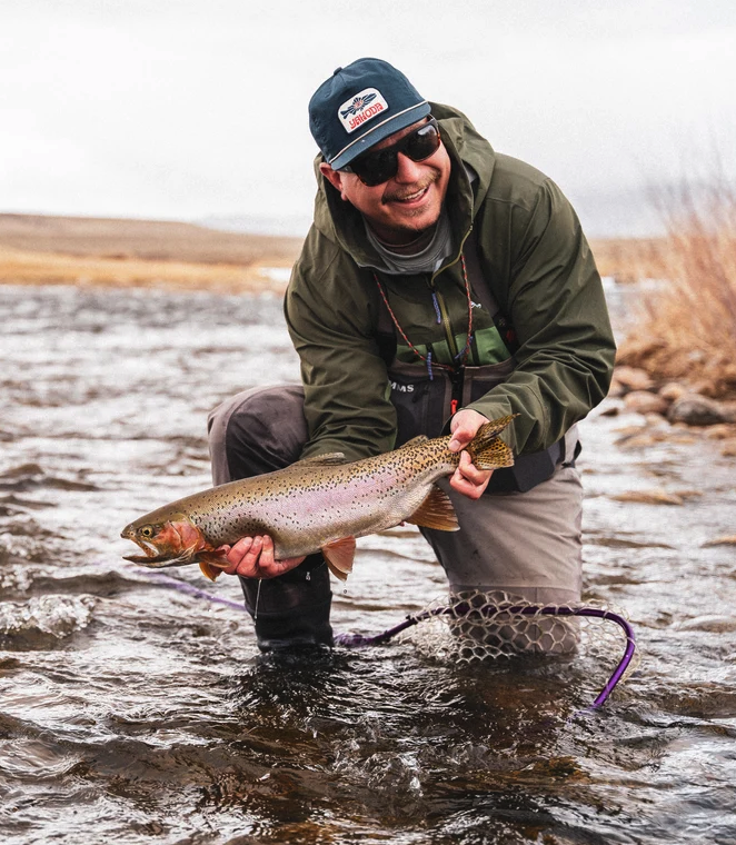 Angler posing with fish and wearing Yakoda Mystic Trout Hat Midnight