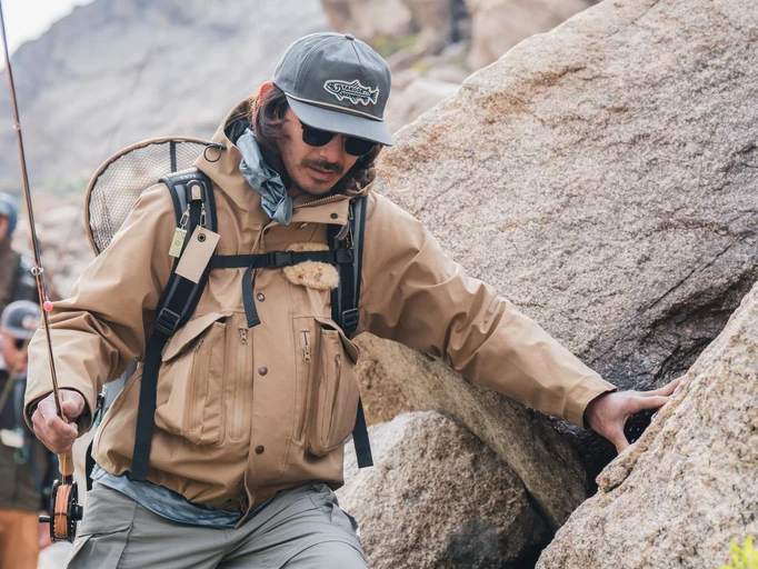 Angler hiking while wearing Yakoda Trout Logo Hat Steel color