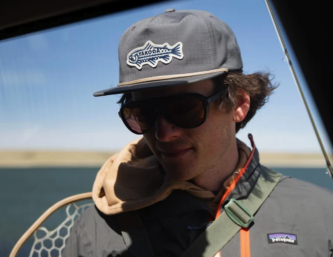 Angler in sunglasses wearing Yakoda Trout Logo Hat Steel